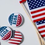 A picture of the US flag and Vote Pins.