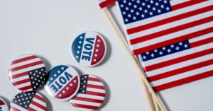 A picture of the US flag and Vote Pins.